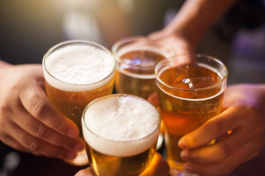 Hands toasting glasses of beer.