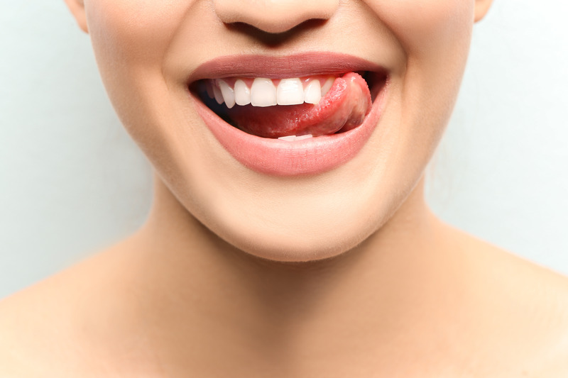 Patient licking their teeth after oral hygiene